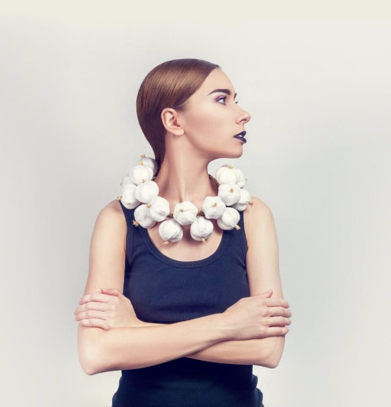 A woman wearing a necklace of garlic bulbs
